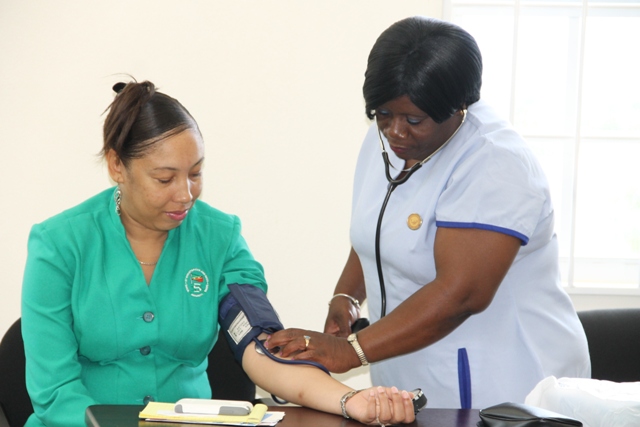 Nurse Jean Tyson administers a blood pressure check to a staff member of the St. Christopher and Nevis Social Security Board branch in Nevis at Pinneys on May 17, 2016
